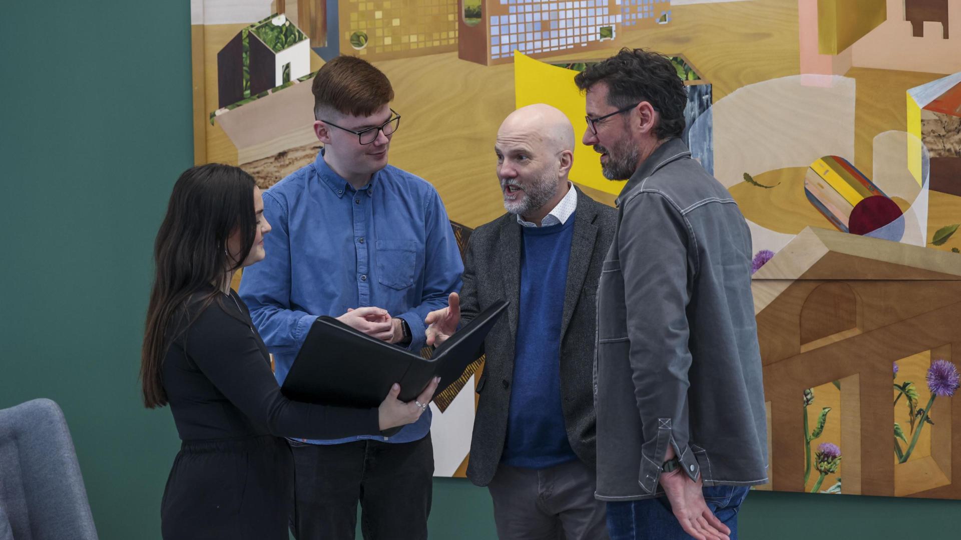 4 people standing up chatting