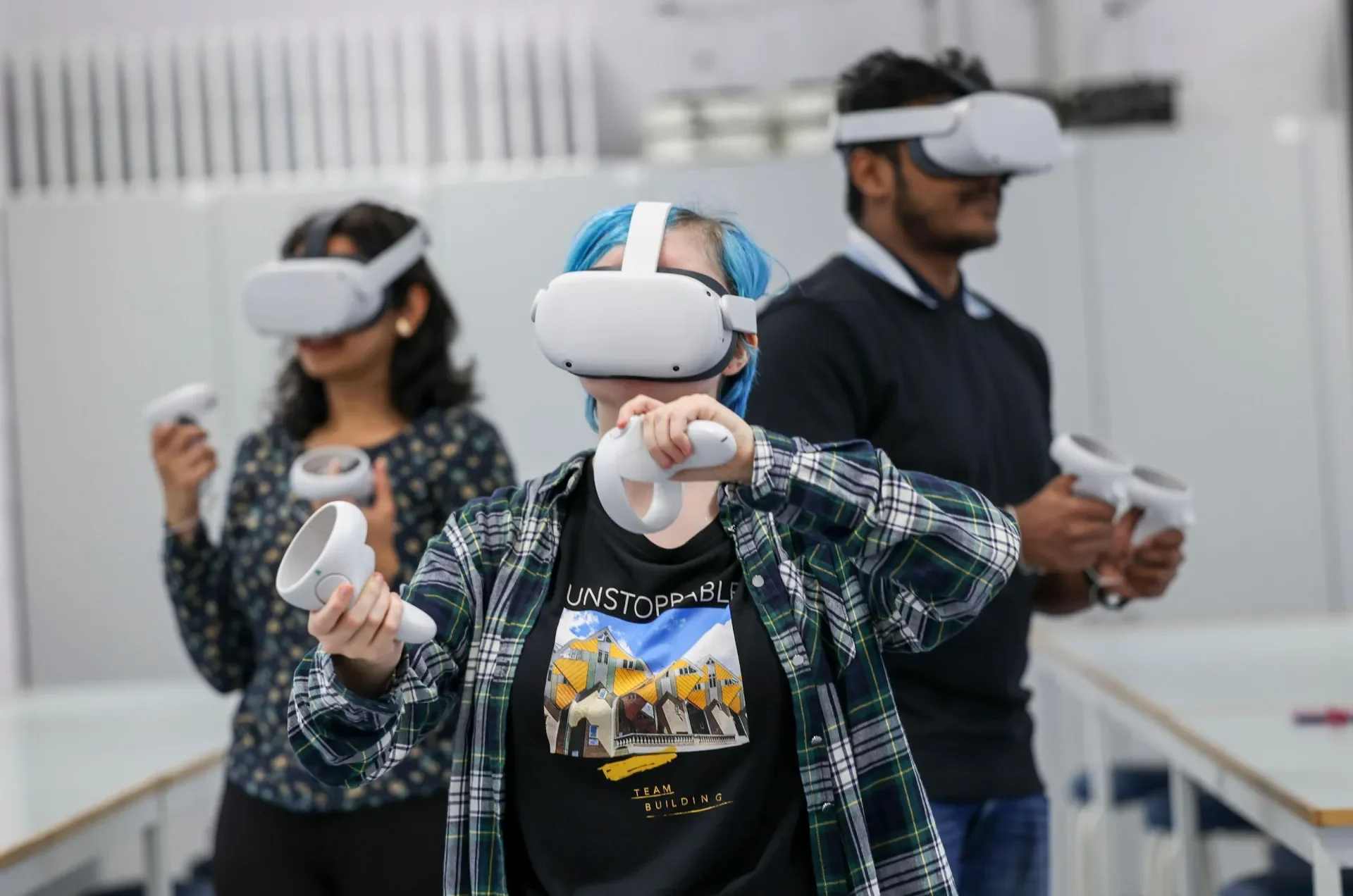 3 individuals using VR equipment in a classroom