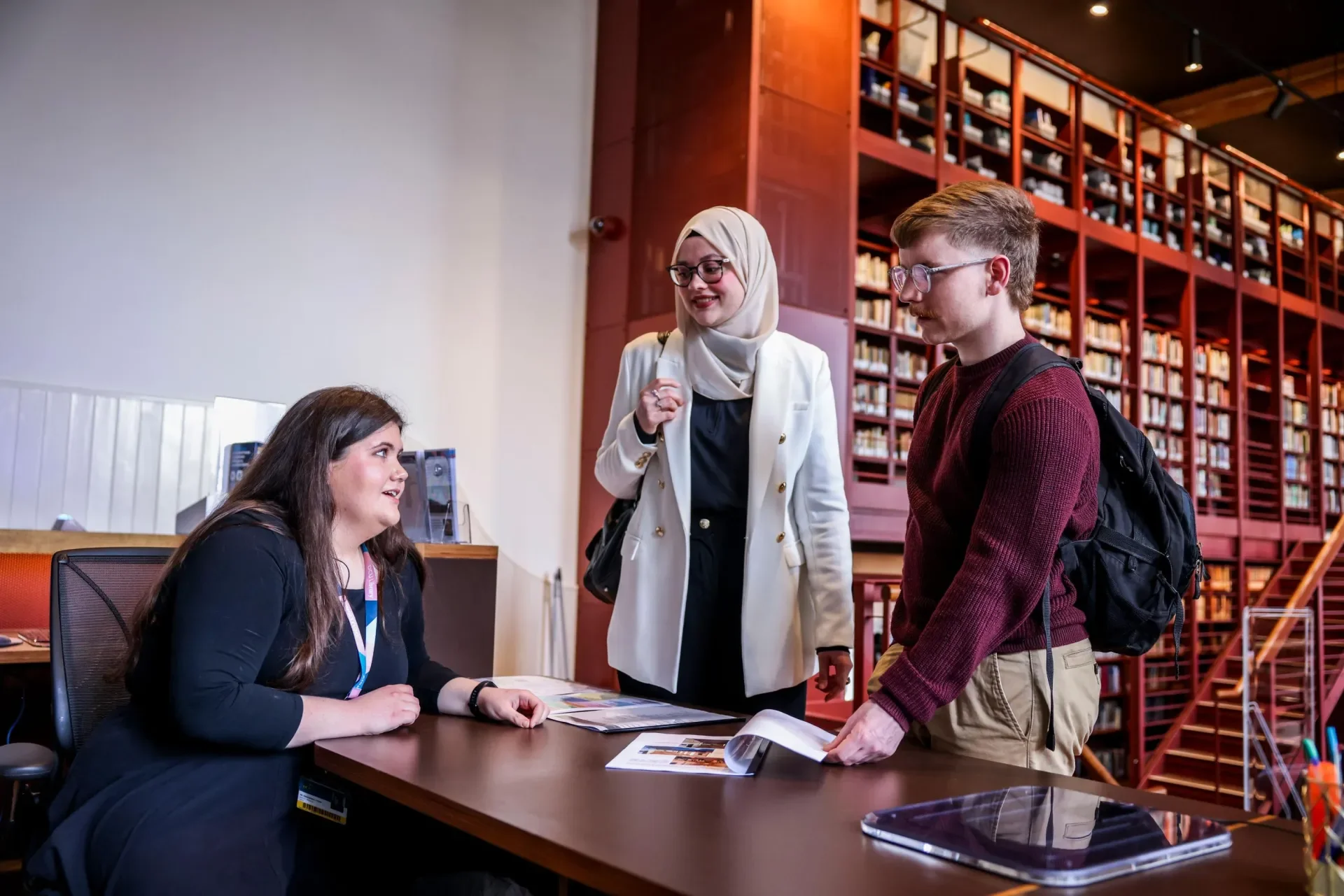 two individuals enquiring at a library desk