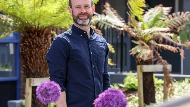 Shows Dr Jimmy O'Keeffe posing amongst plants on DCU's Glasnevin campus