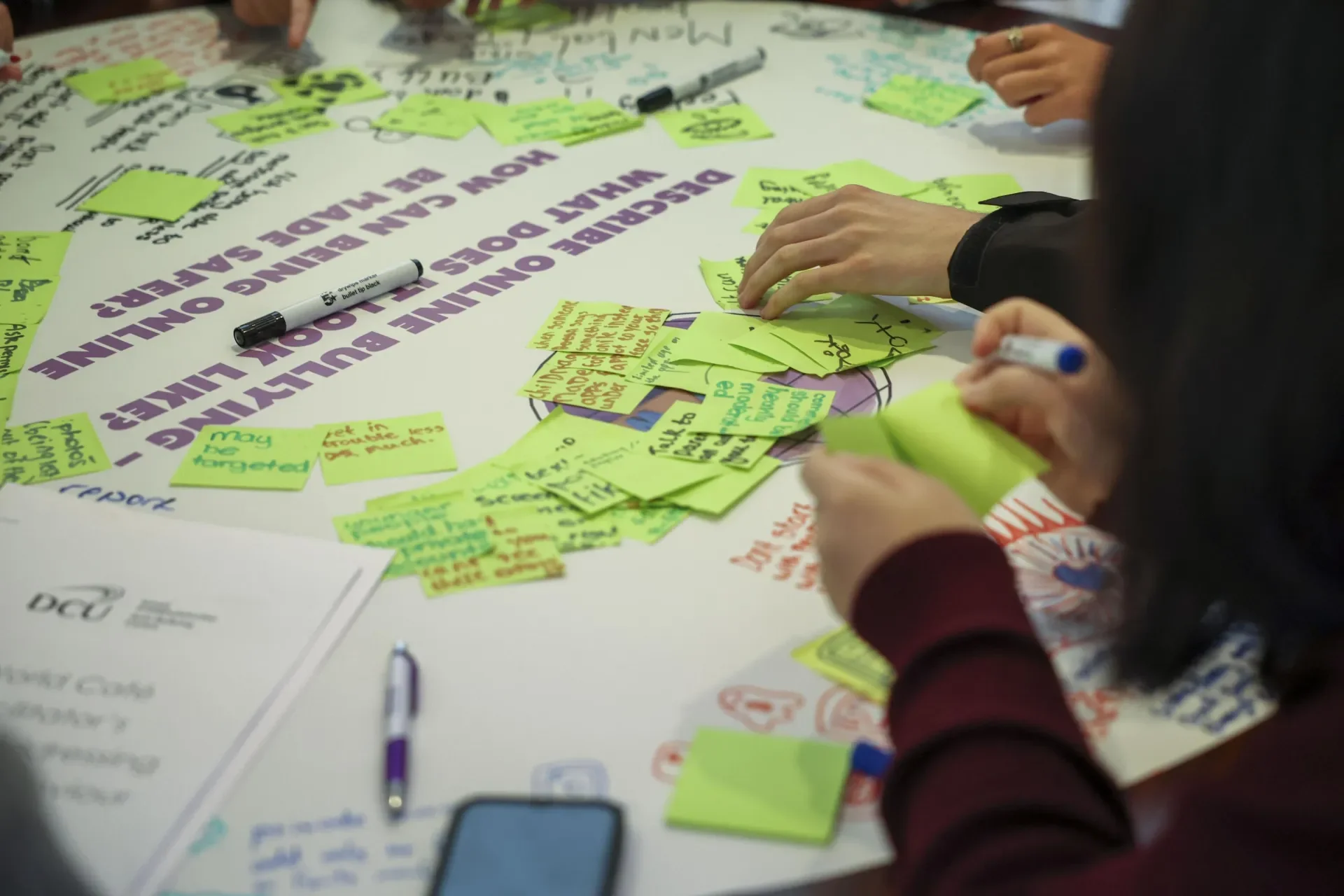 Shows students filling out stick notes with their thoughts on bullying