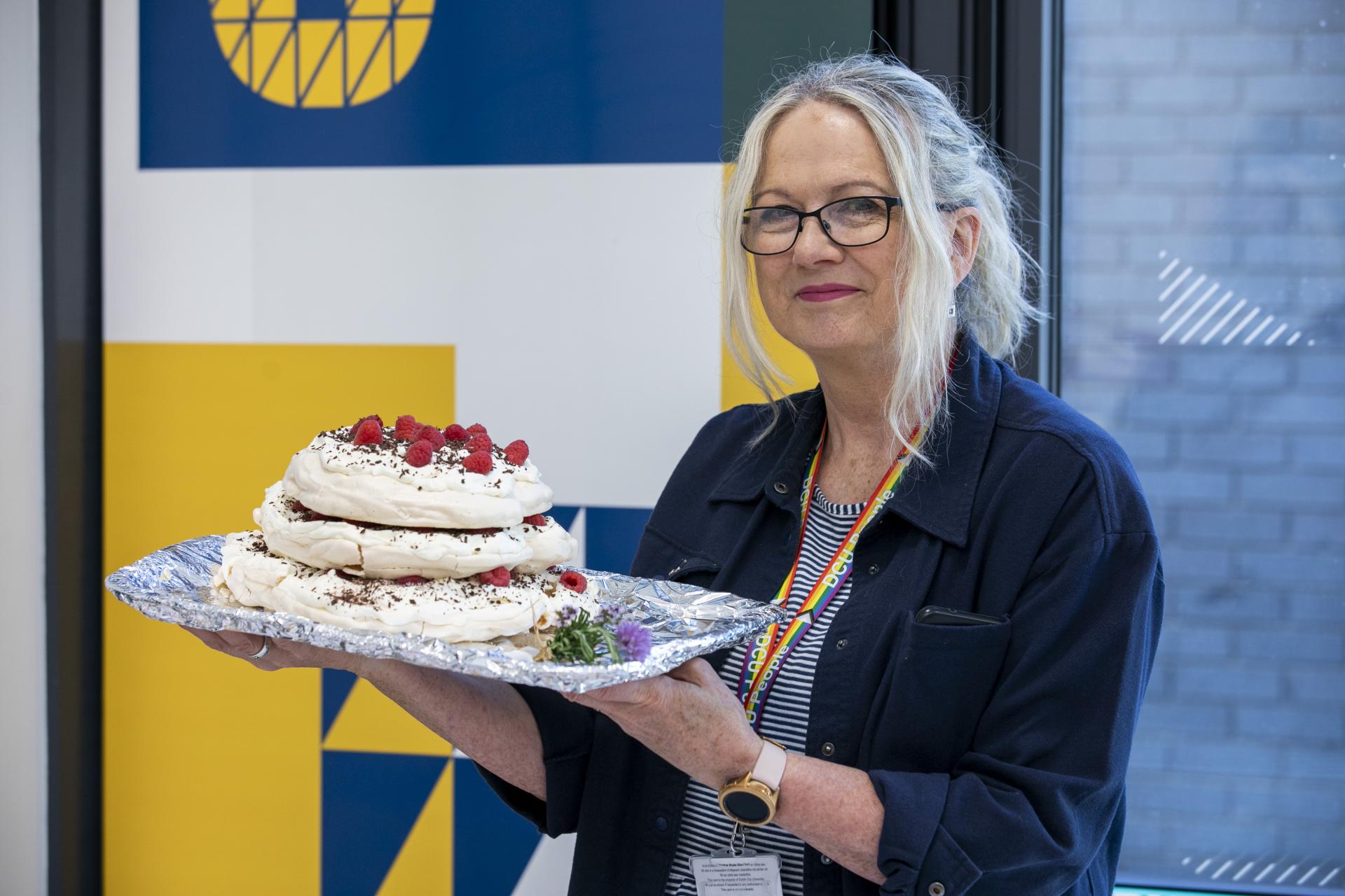Shows Debbie with her cake at the DCU Bake off for Barretstown
