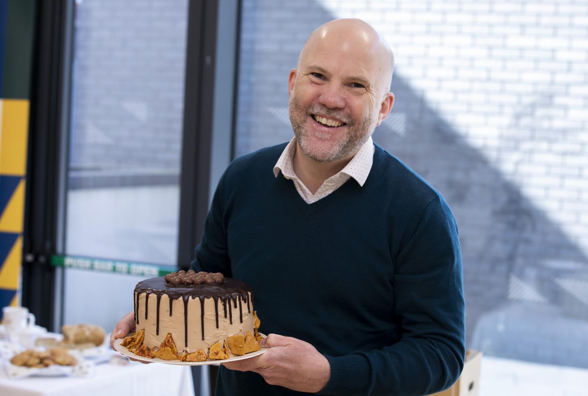 Shows Tom Swift with his Chocolate Drip Cake during the DCU Bake Off for Barretstown