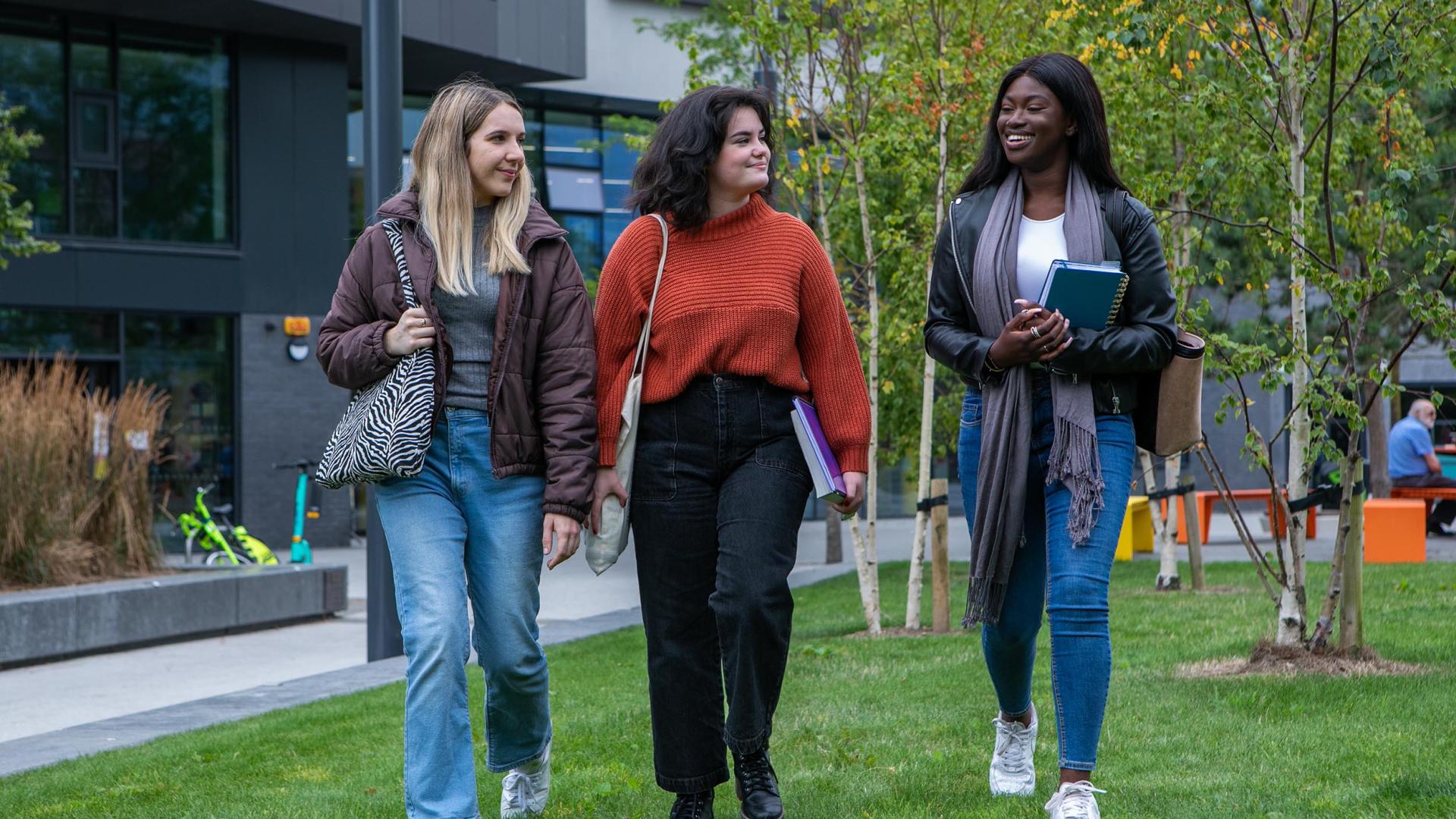 shows three female students walking together on DCU's Glasnevin campus