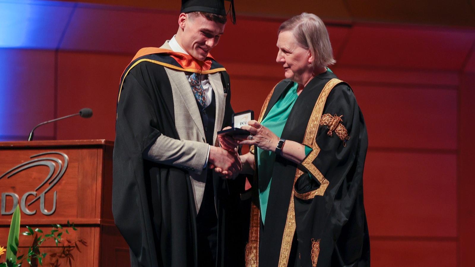 Shows Jordan Morrissey receiving his Chancellor's Medal from DCU Chancellor Brid Horan