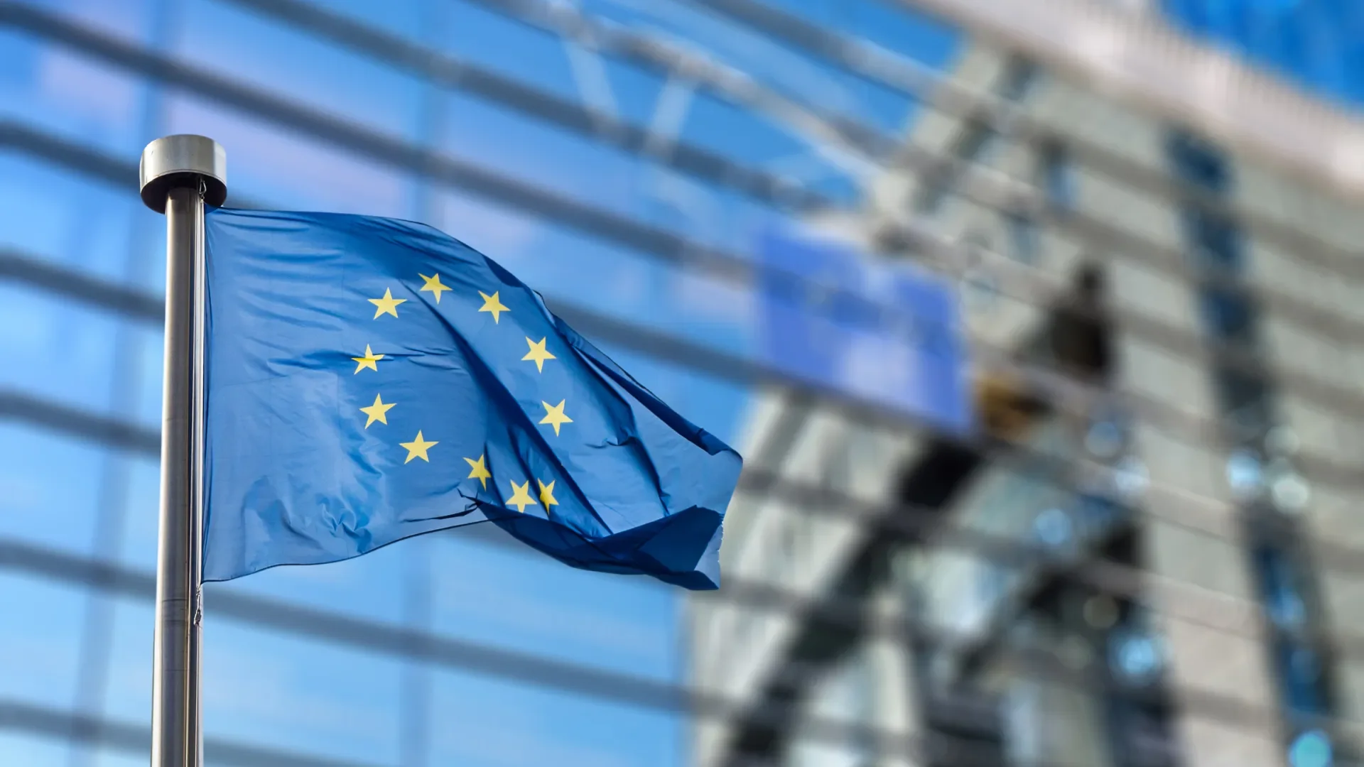 Shows European Union flag flying outside the European Commission's headquarters in Brussels