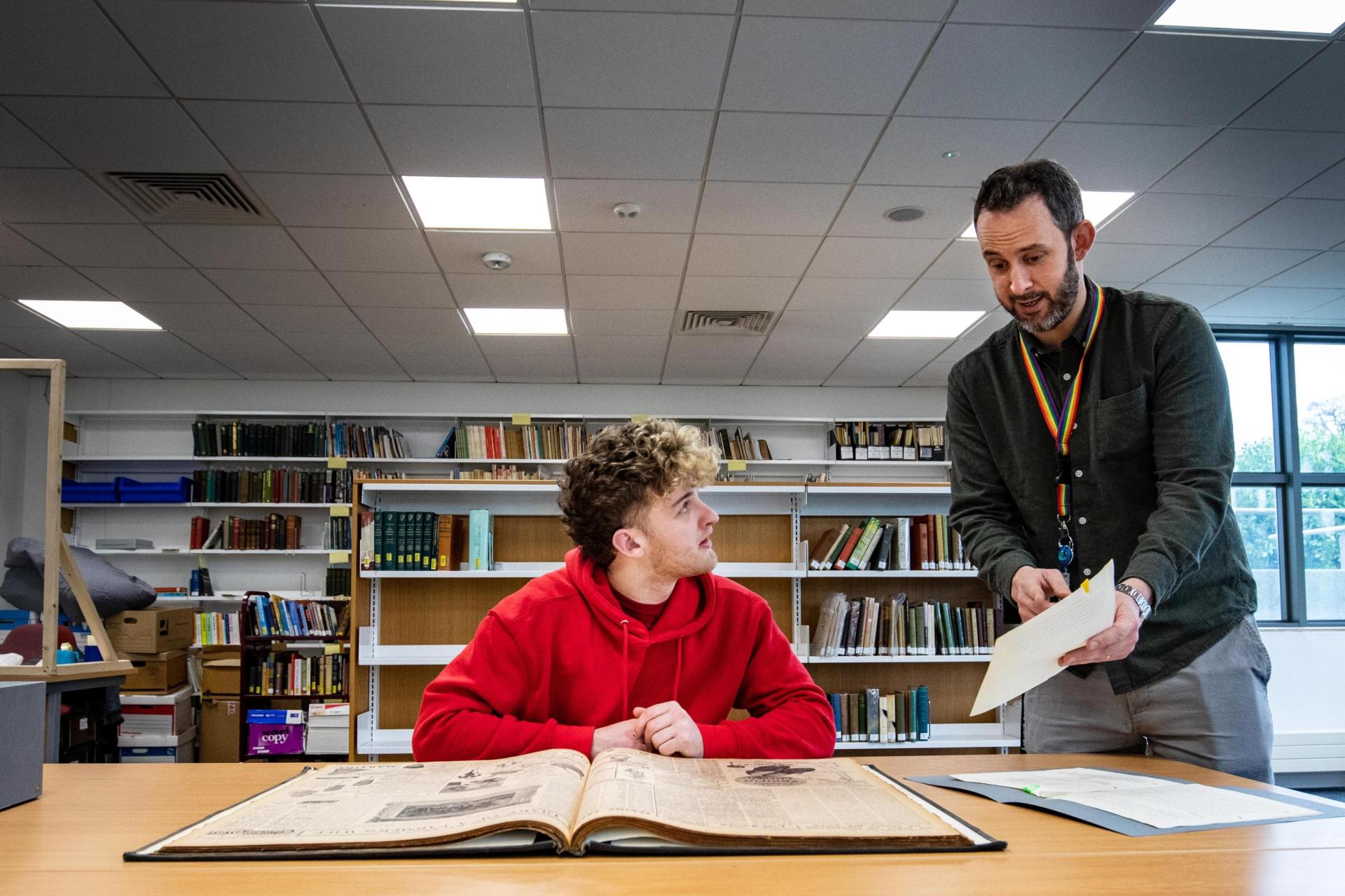 A student with archivist Killian Downing in the Special Collections & Archives reading room.