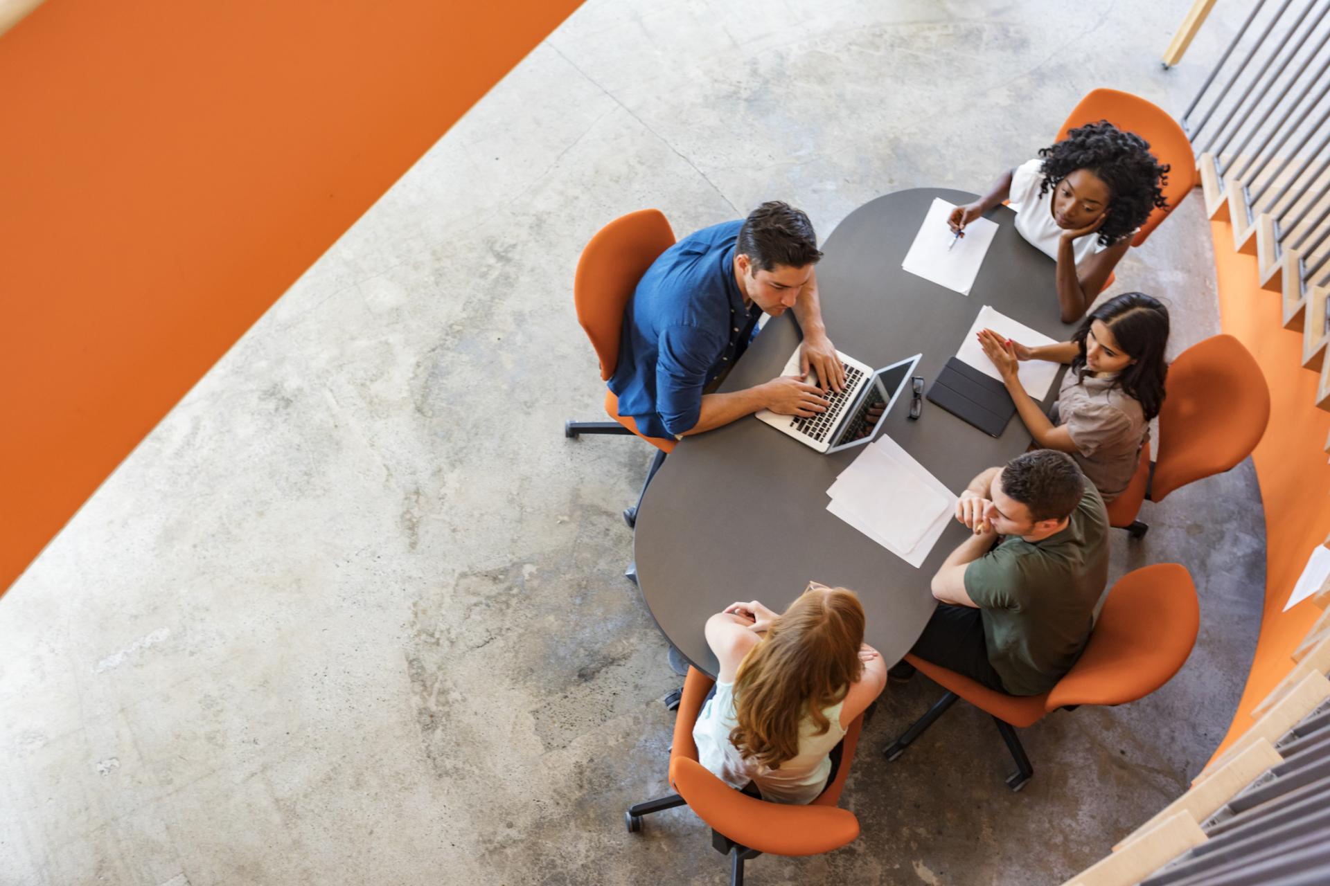 A group of colleagues sitting around a conference table having a discussion.