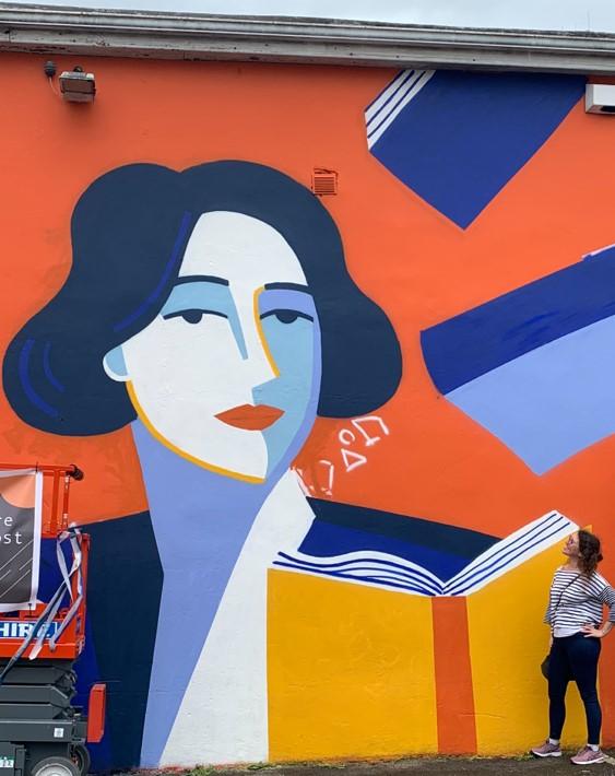 Sharon Mc Ardle poses next to a Dorothy Macardle ‘work in progress’ mural  in Dundalk. Claire Prouvost, a French illustrator and graphic designer created this mural. 