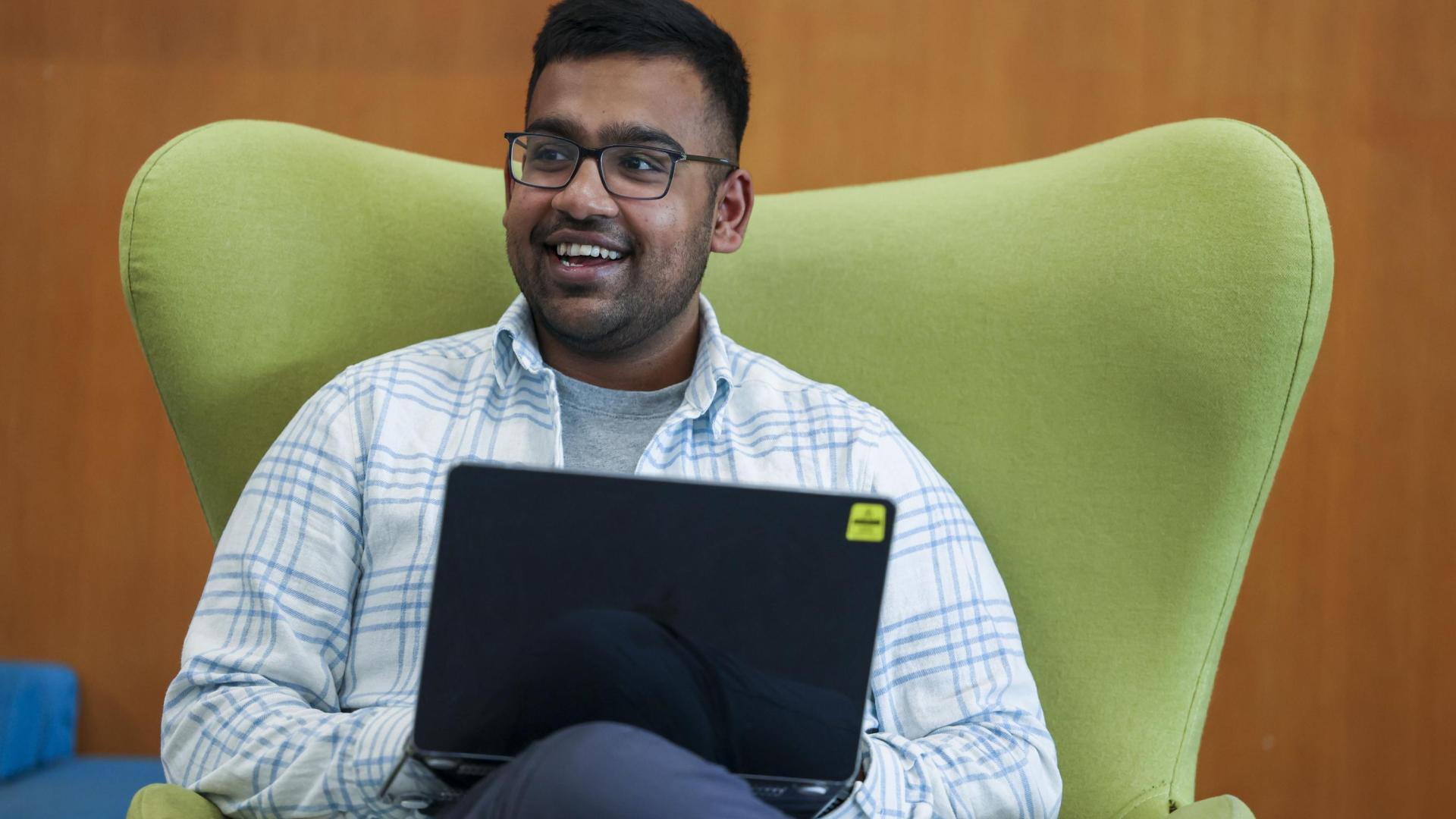 smiling student using a laptop