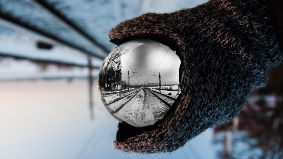 Gloved hand holding a metal ball