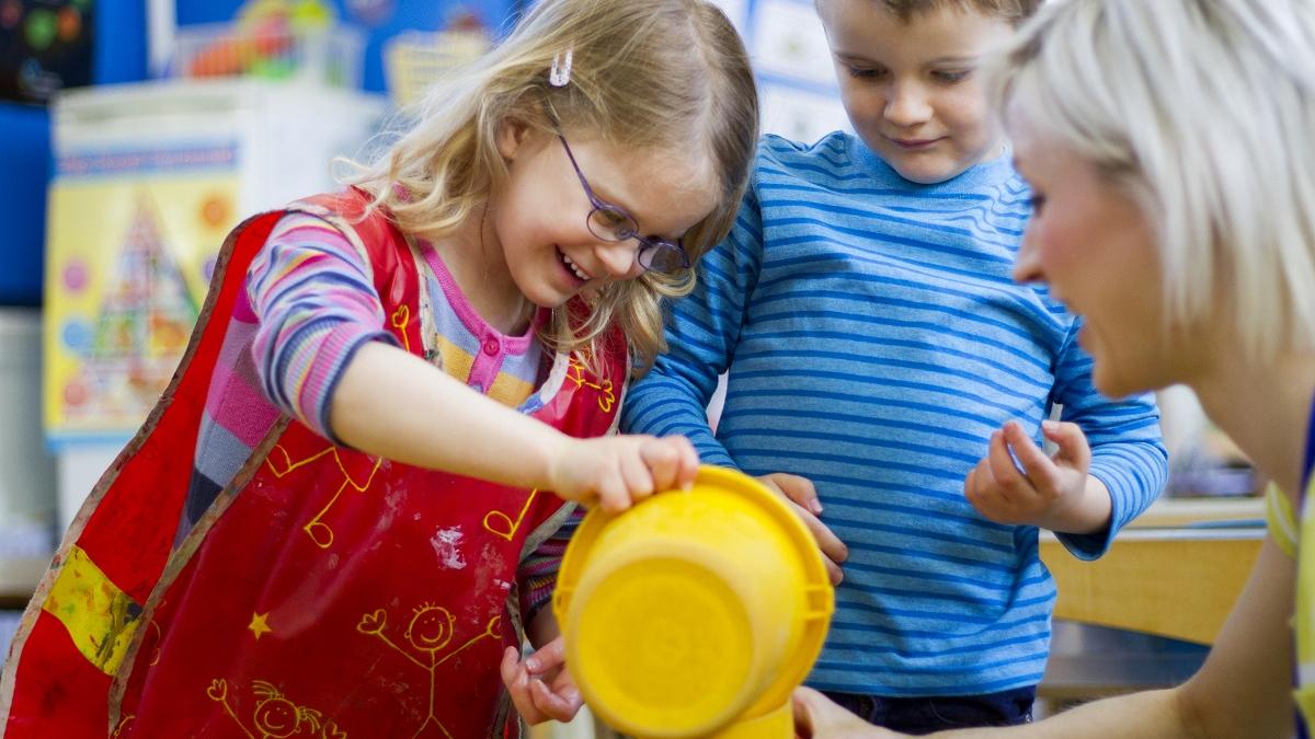 Early school child pouring from a jug